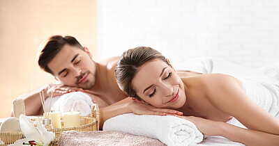 Young couple with spa essentials in wellness center Young couple with spa essentials in wellness center